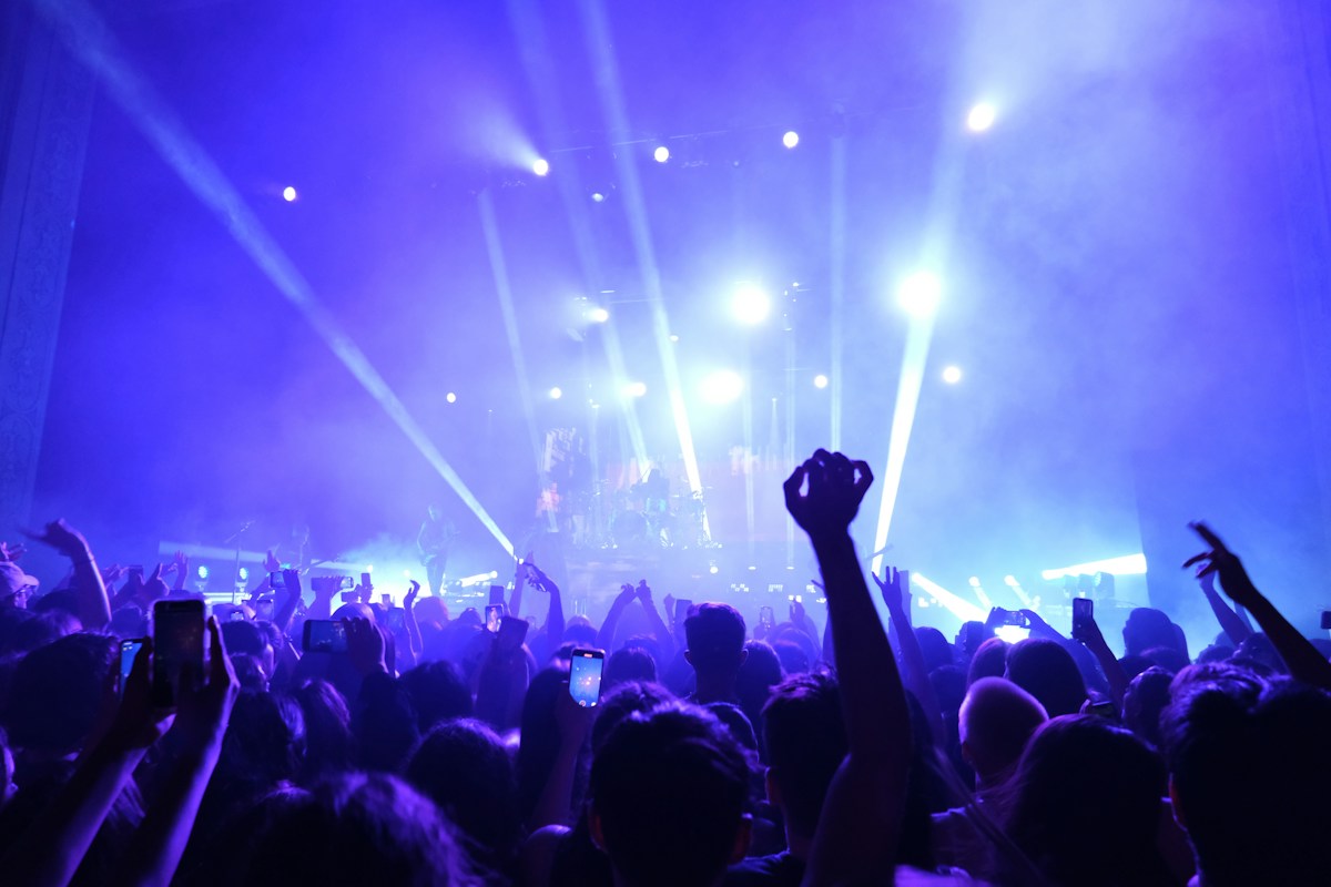 Illustrative concert crowd beneath stage lighting